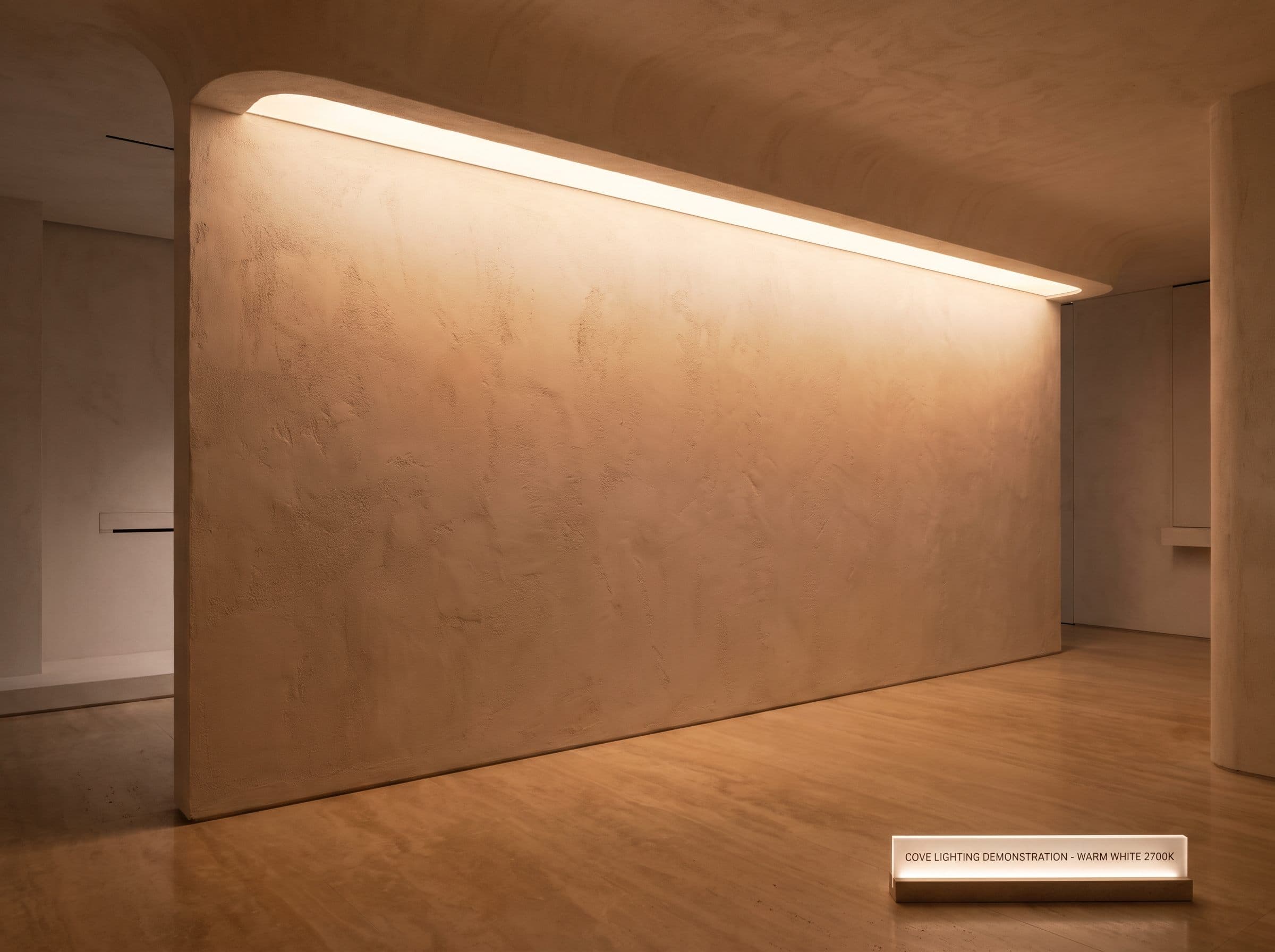 Demonstration wall showing concealed cove lighting washing down from a plaster ceiling recess